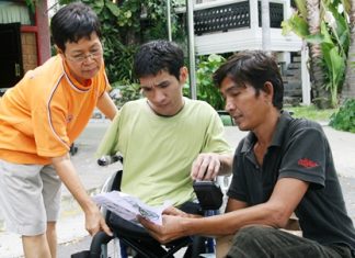 Den, center, receives the instructions for his new wheelchair.